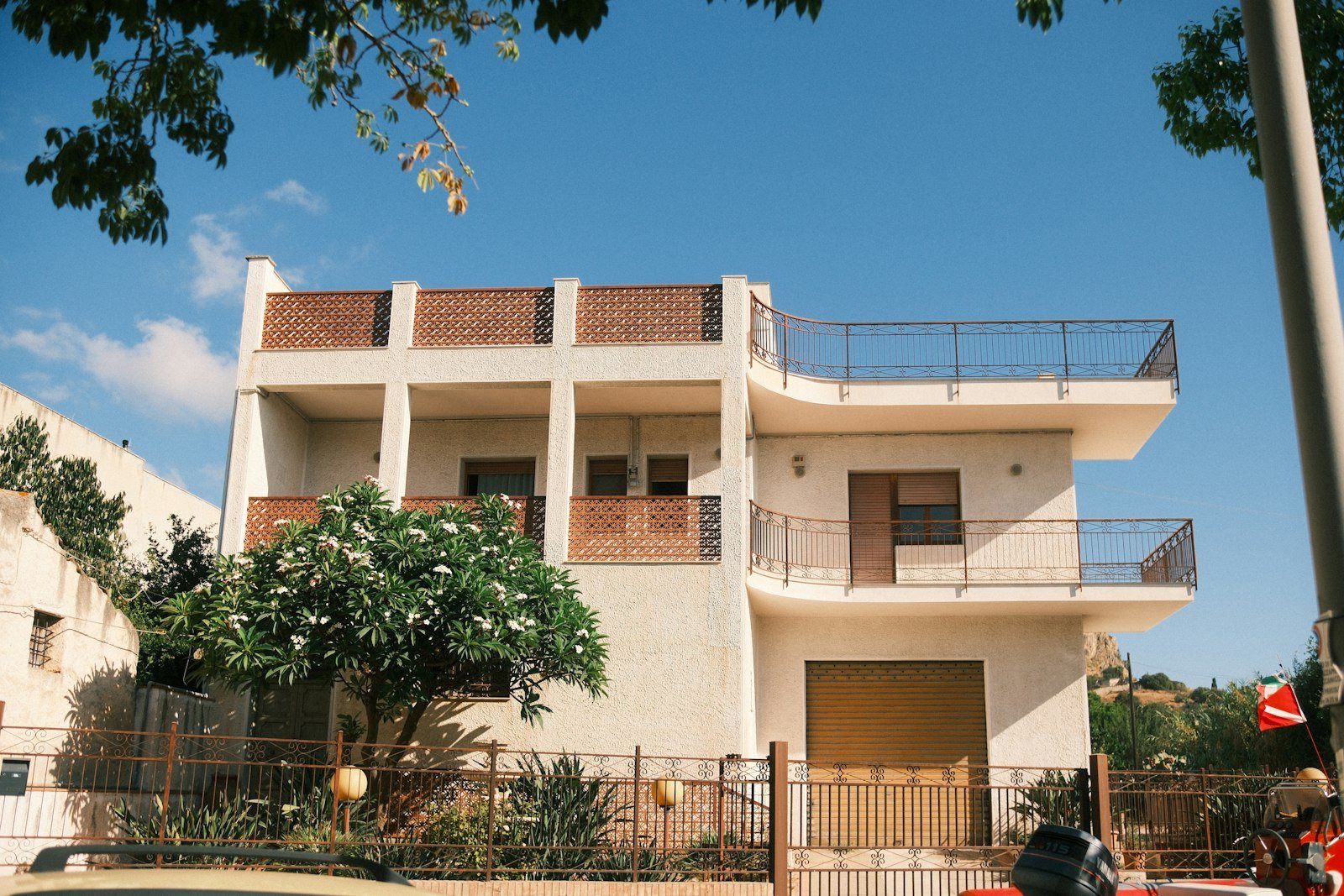 Maison blanche sur trois niveaux avec balcons et jardin