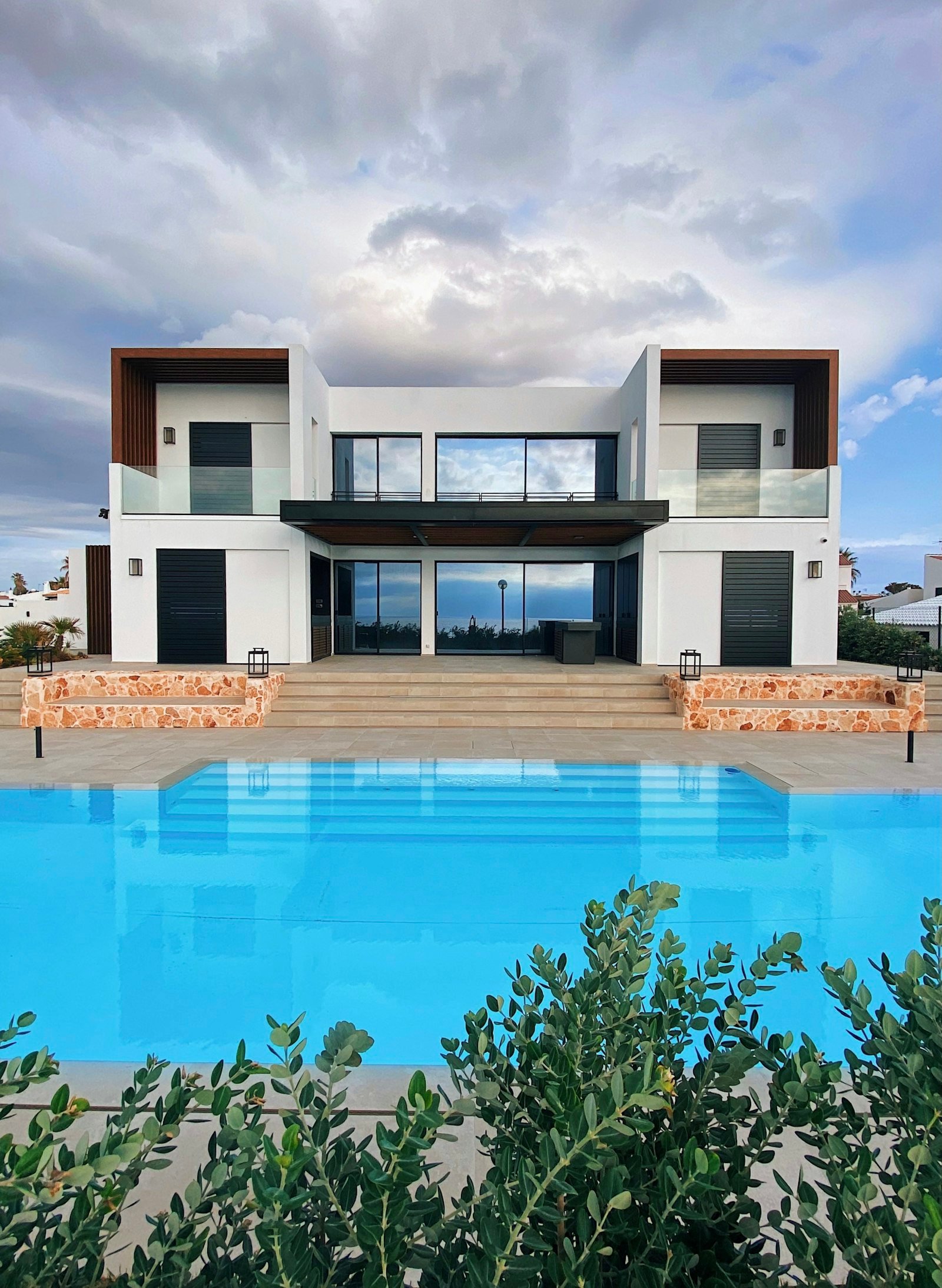 Villa blanche avec grande piscine au premier plan