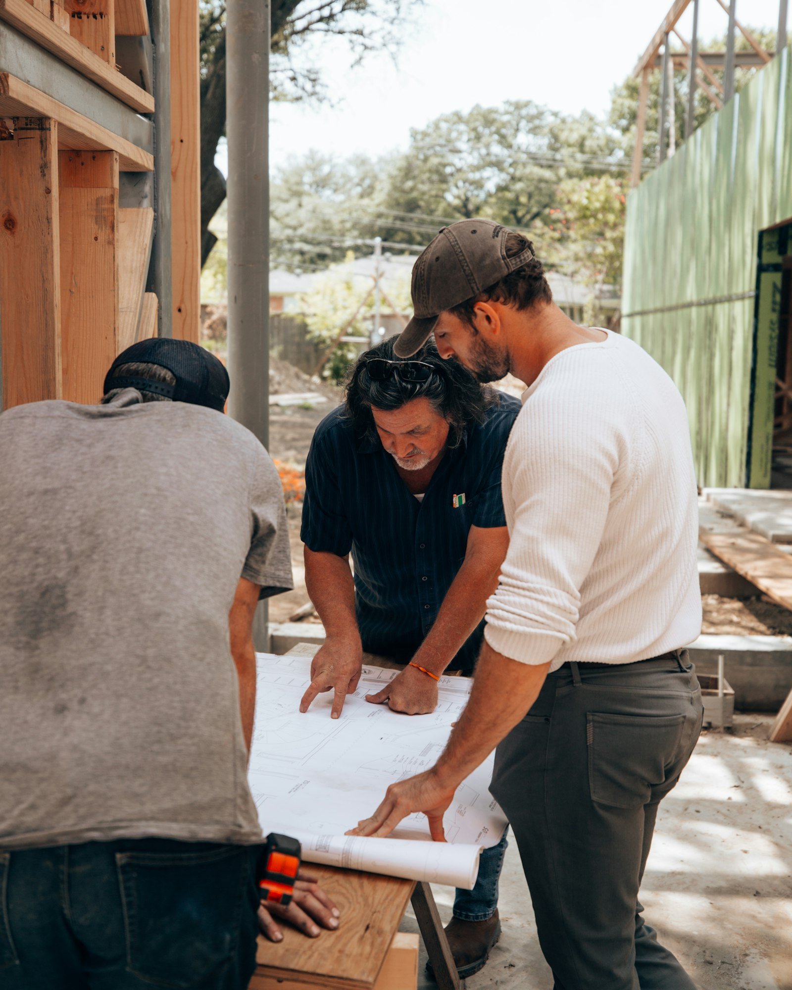 Chef de chantier et artisans étudiant les plans sur le chantier